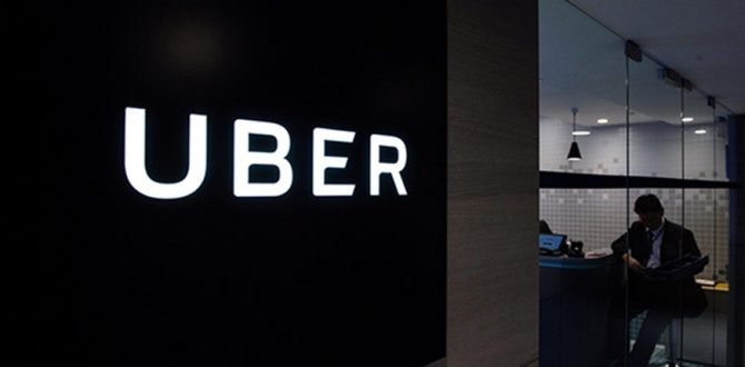 Uber signage is seen as an employee sits in the entrance of the ride hailing giants office in Hong Kong 670x330 - Uber Takes on Commuting With Express Car Pool Service